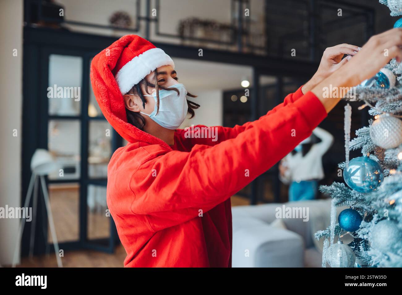 Guy in Hat si alza da abete albero. Festival e arredamento concetto. Foto Stock