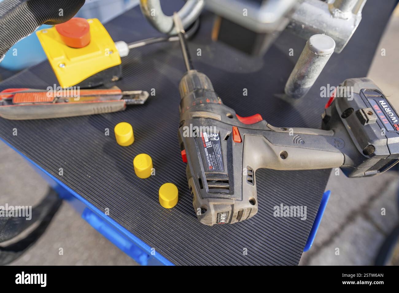 Utensili su un tavolo con cacciavite a batteria, coltello da taglio e cappucci gialli, installazione di tubi in fibra ottica Wend Glasfasermontage per cavi in fibra ottica Foto Stock