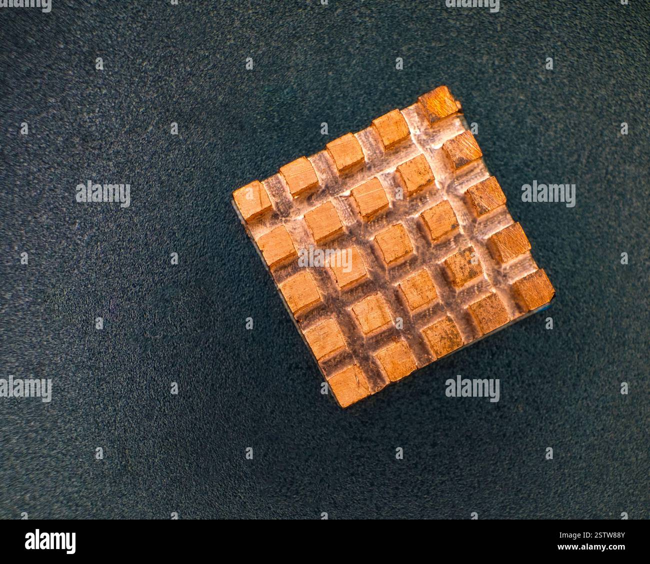 Nuovo elemento di raffreddamento in rame su sfondo in plastica nera. Dissipatore di calore in rame. Foto Stock