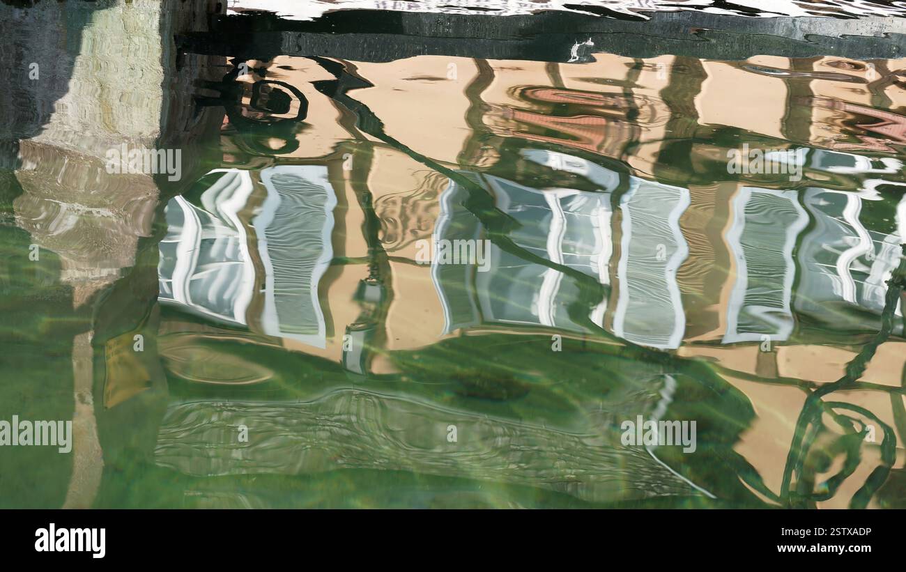 Riflesso delle finestre architettoniche in una superficie d'acqua ondulata tranquilla Foto Stock