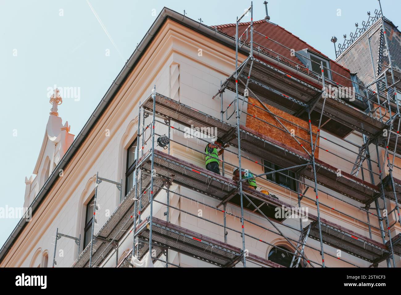 Casa in fase di ristrutturazione. Riparazioni alla facciata dell'edificio. I lavoratori possono anche essere visti sul posto di lavoro. Foto Stock