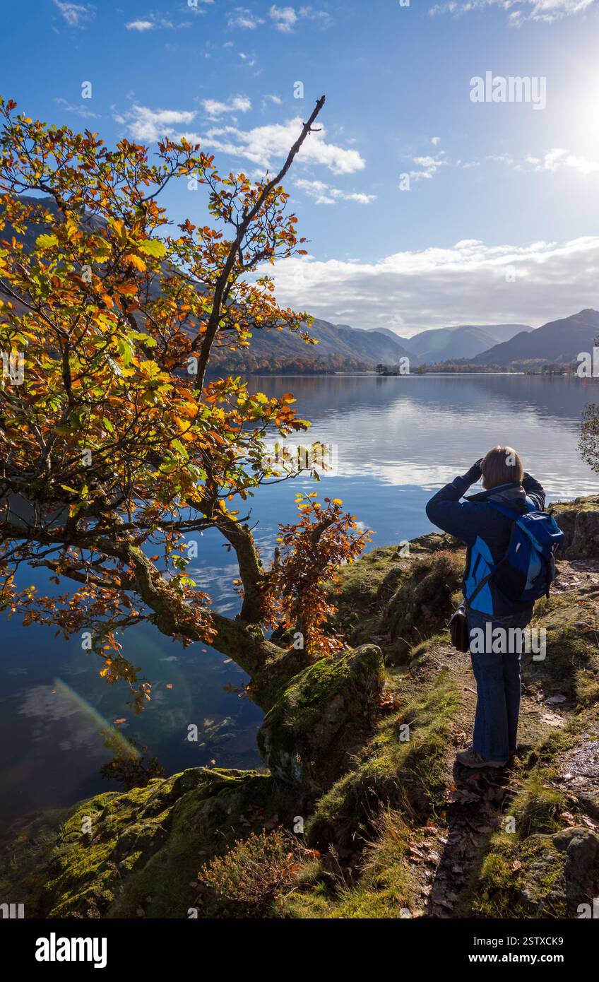 I turisti ammirano le riflessioni nelle calme acque del lago Ullswater sulla Ullswater Way a novembre, Glenridding, Lake District, Cumbria, Inghilterra, REGNO UNITO Foto Stock