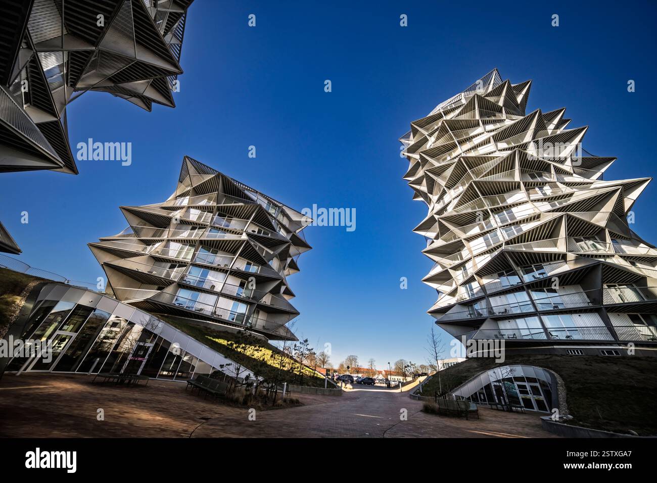 Un'architettura moderna unica e sorprendentemente angolata posta su un cielo azzurro e vivace, presenta un design innovativo e un'audace estetica urbana. Foto Stock