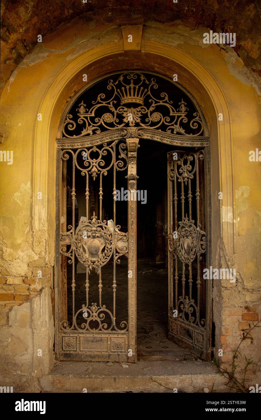 Porta bar di ferro di una villa europea abbandonata Foto Stock