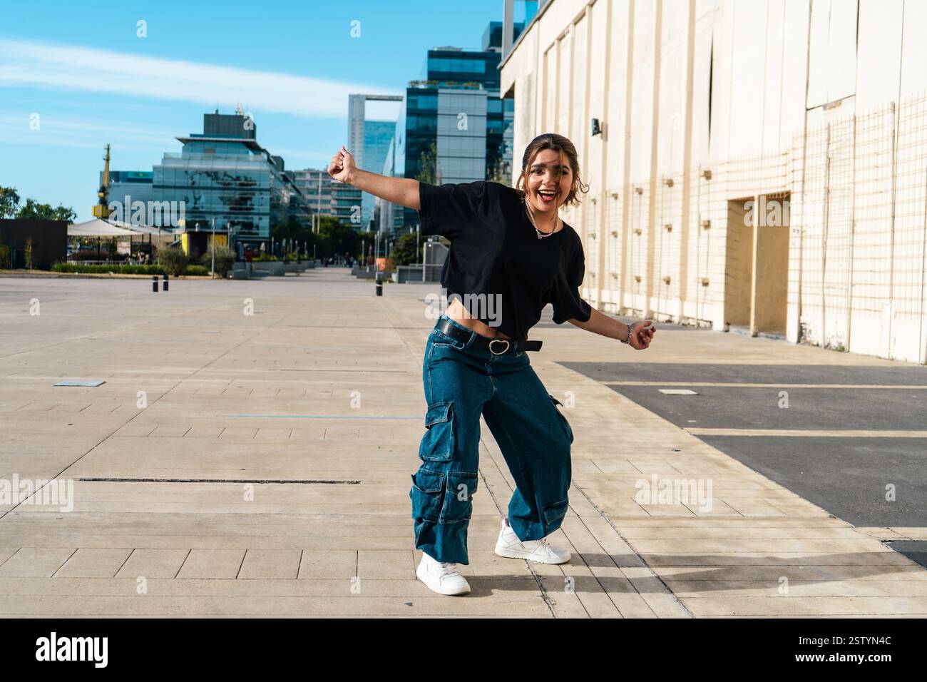 Donna che ama ballare spensieratamente in un paesaggio urbano moderno Foto Stock