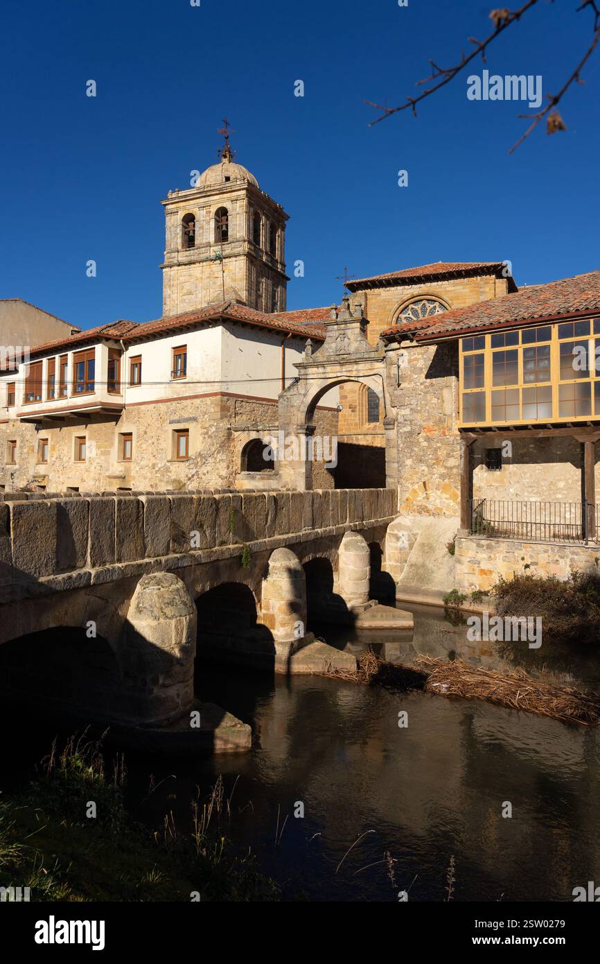 Il campanile della chiesa di San Miguel e il ponte e la porta di Portazgo nel villaggio storico di Aguilar de Campoo, Palencia, in Spagna, in una giornata di sole. Foto Stock