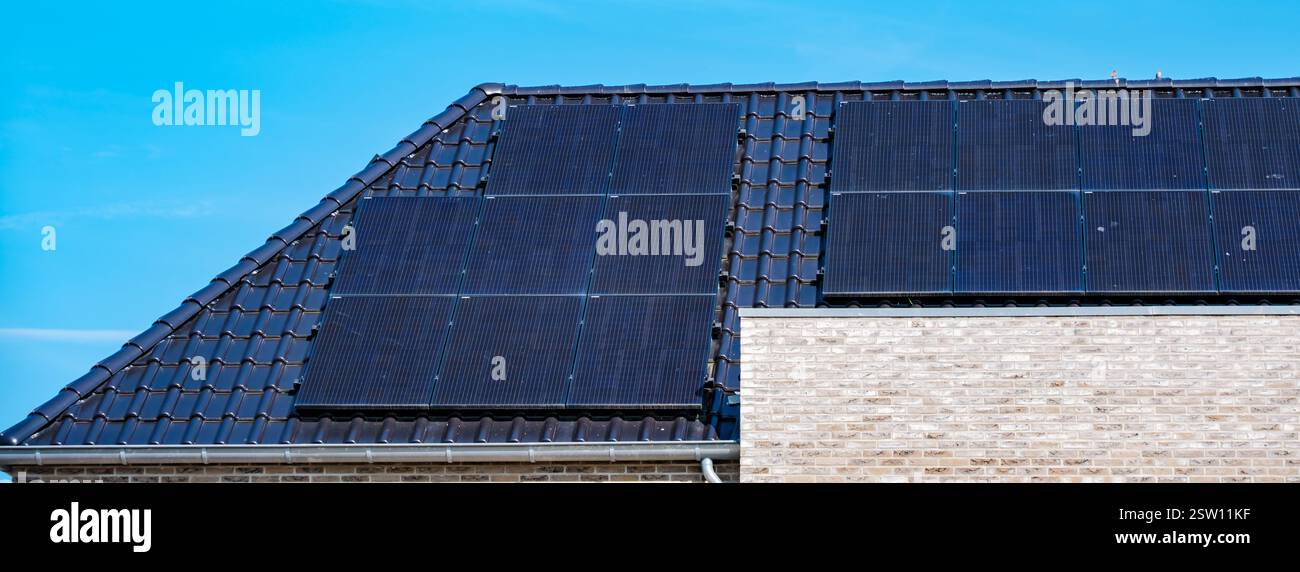 Pannelli solari efficienti che sfruttano la luce del sole su un moderno tetto Foto Stock