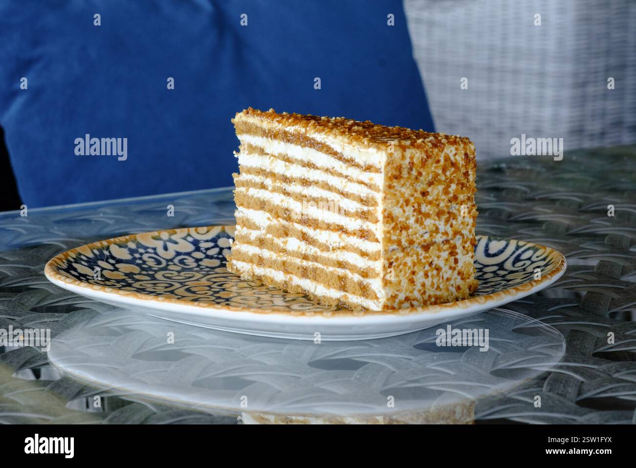 Una fetta di torta a strati con un condimento croccante servita su un piatto decorativo Foto Stock