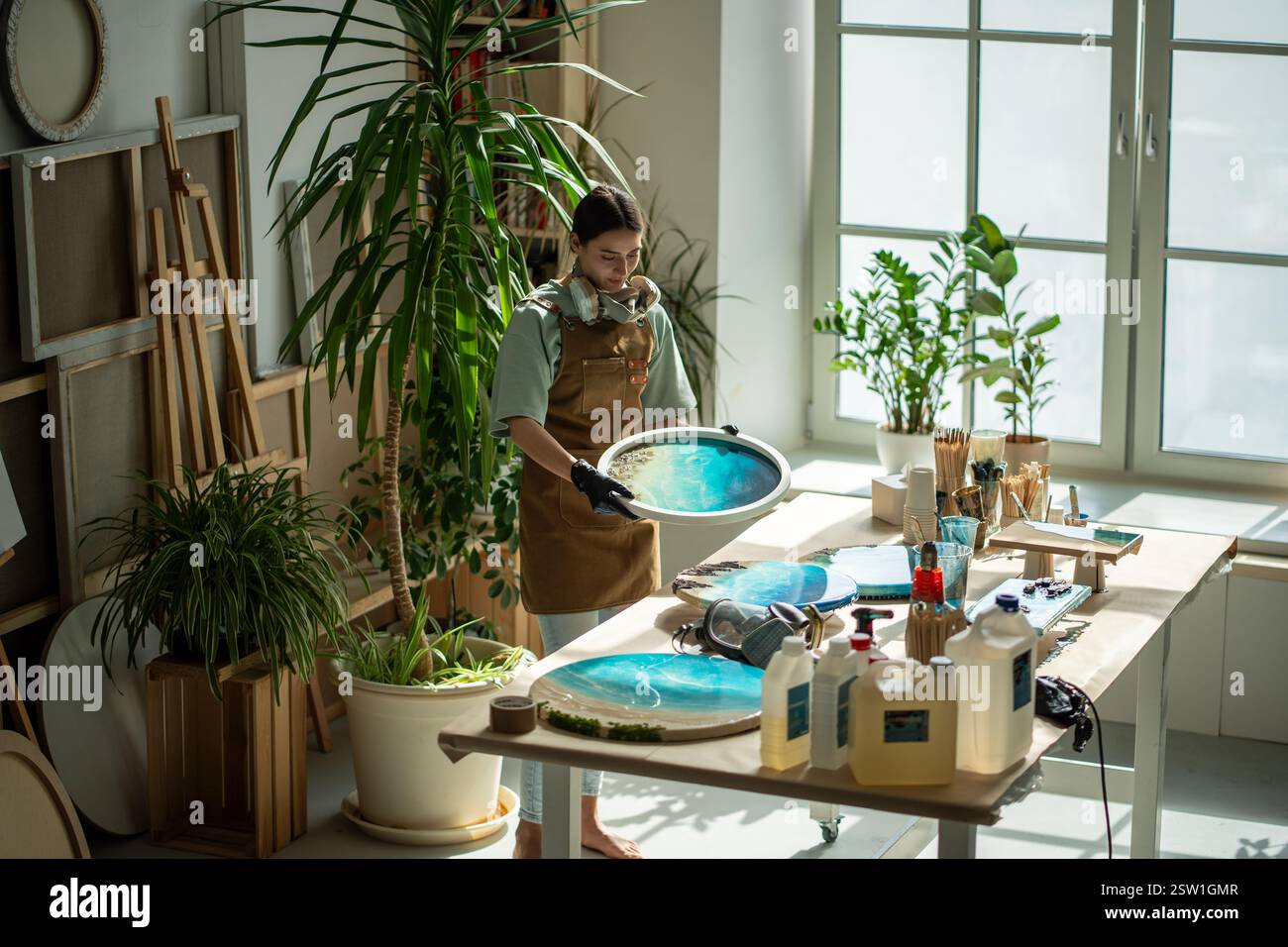 Le donne artiste creano una tela d'arte alla moda realizzata a mano in stile arte liquida in un luminoso laboratorio domestico. Foto Stock