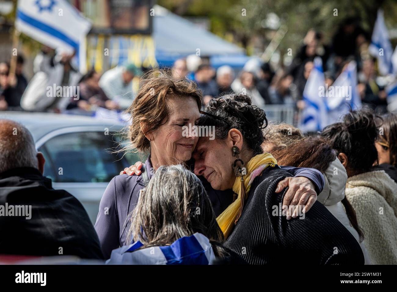 Due donne si confortano a vicenda mentre aspettano che il convoglio trasporti i corpi degli ostaggi israeliani fuori dal Centro Nazionale di Medicina Forense Abu Kabir a Tel Aviv giovedì 20 febbraio 2025. Hamas ha rilasciato giovedì i corpi di quattro ostaggi israeliani, i resti si diceva fossero di Shiri Bibas e dei suoi due figli, Ariel e Kfir, così come di Oded Lifshitz, che aveva 83 anni quando è stato rapito. Hamas ha detto che tutti e quattro sono stati uccisi insieme alle loro guardie in un attacco aereo israeliano. Foto di Eyal Warshavsky. Foto Stock