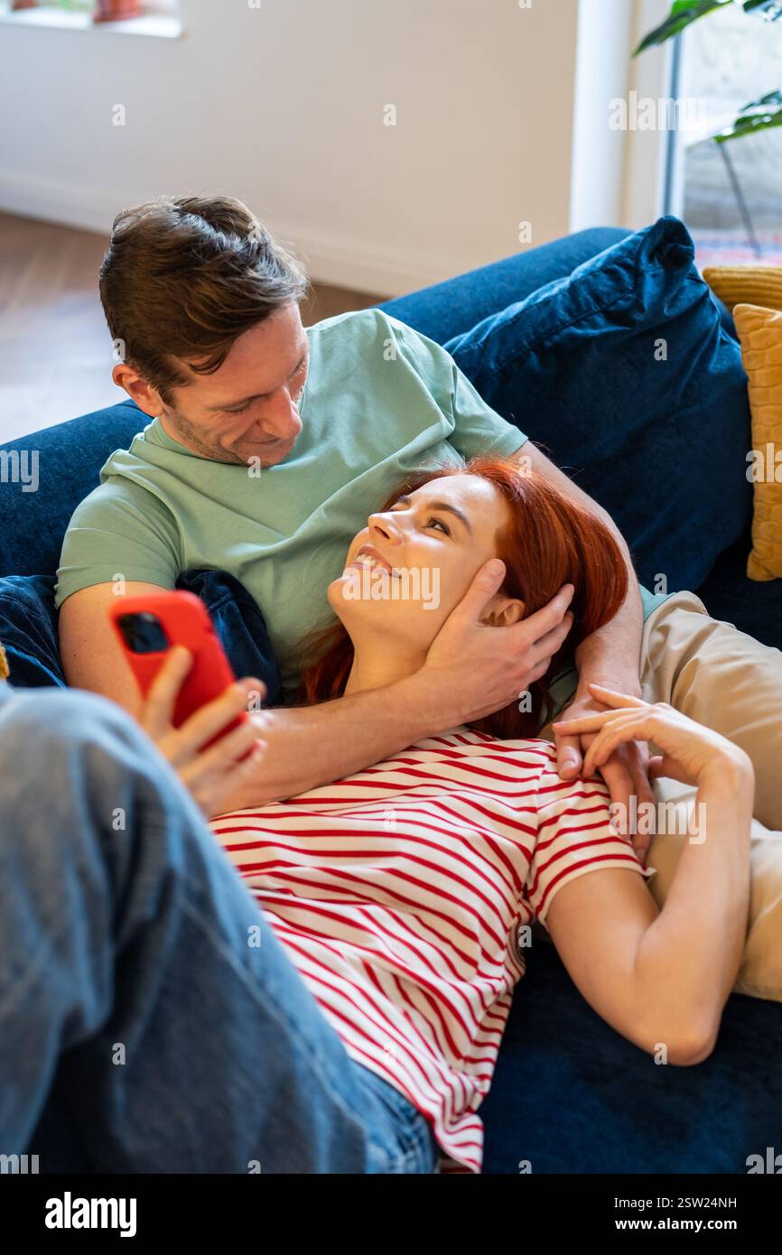 Giovane coppia uomo e donna che riposano sul divano, godendosi la vita coniugale Foto Stock