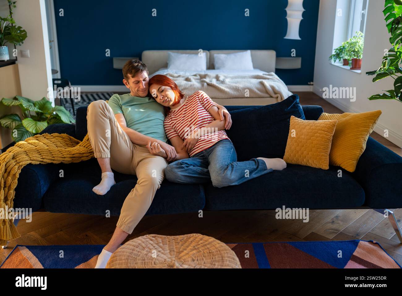 Coppia innamorata seduta sul divano e tenere le mani, abbracciando nel proprio appartamento. Connessione emotiva Foto Stock