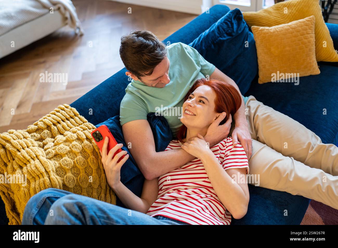 Giovane coppia uomo e donna che riposano sul divano, godendosi la vita coniugale Foto Stock