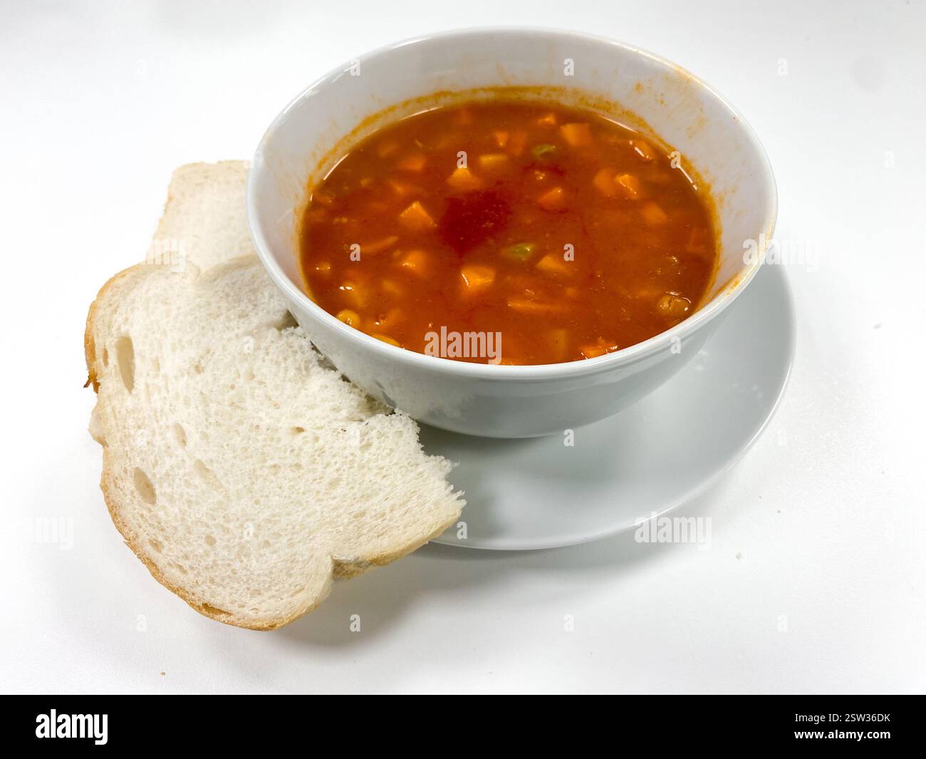 Una ciotola di zuppa di verdure con un po' di pane per pranzo Foto Stock