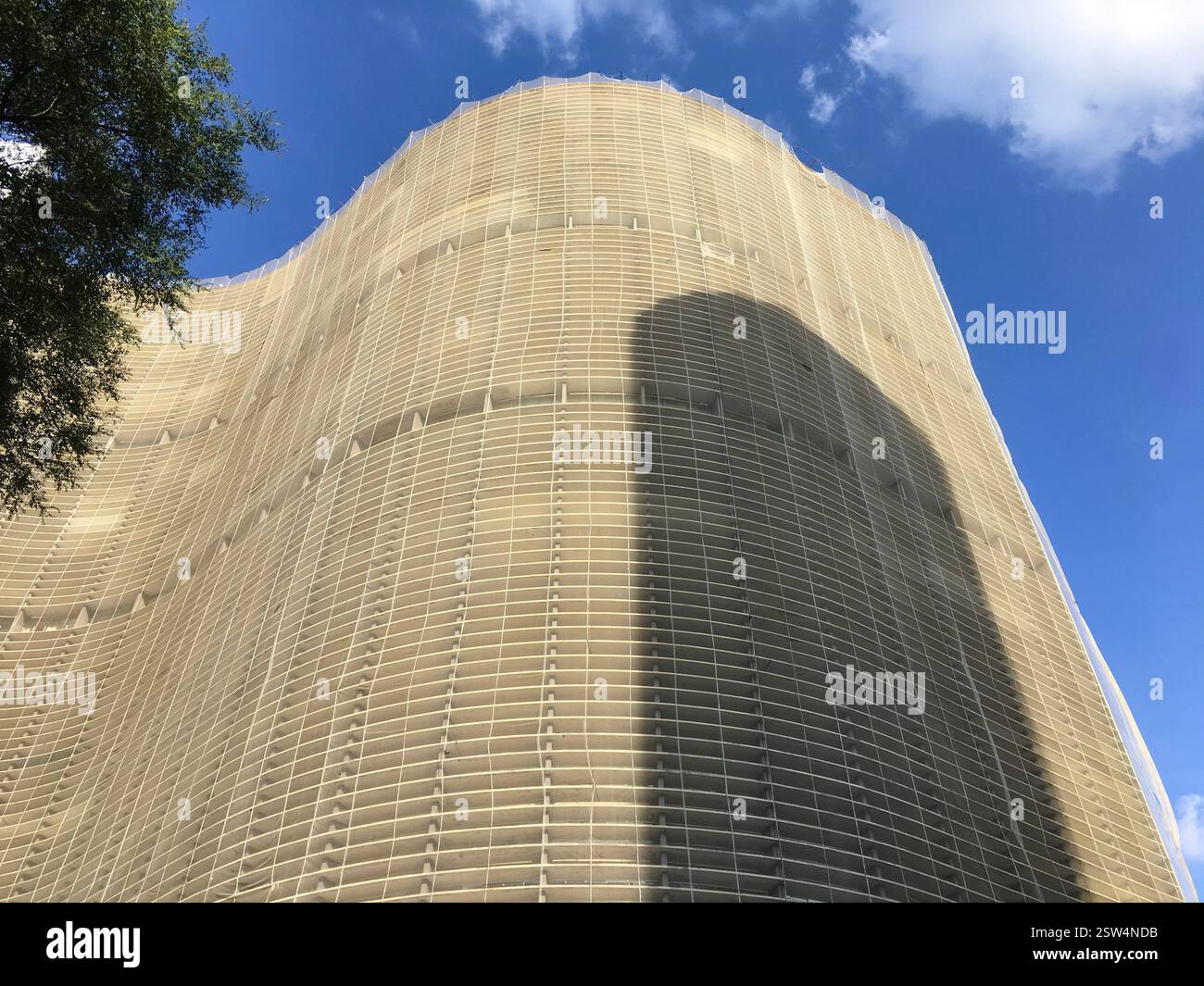 Una struttura architettonica moderna con una facciata ondulata unica e un esterno a griglia che proietta ombre spettacolari. Foto Stock