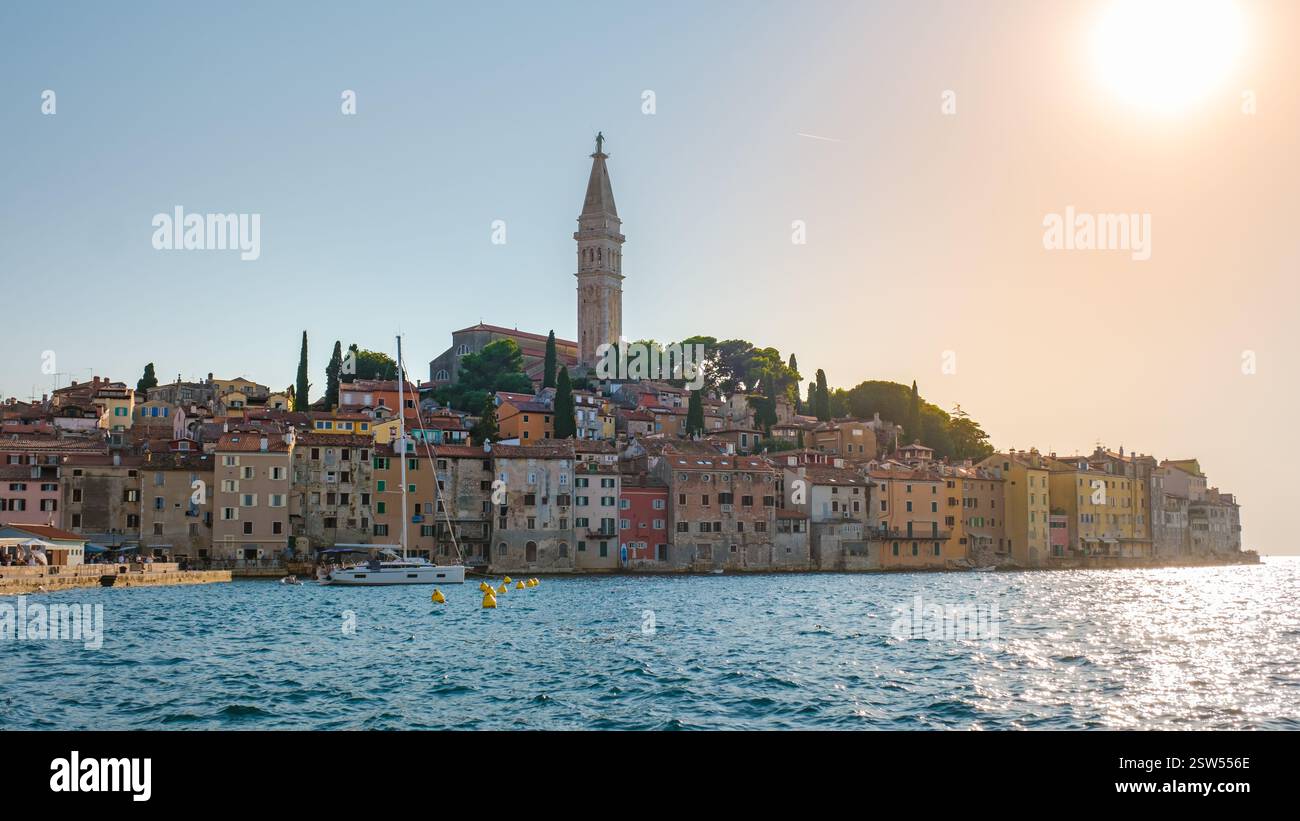 Lo splendido tramonto di Rovigno mette in risalto la vibrante architettura costiera e i monumenti storici Foto Stock