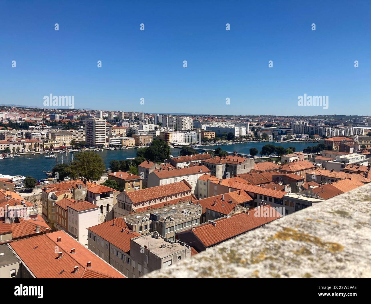 Vista panoramica della città vecchia di Zara in Croazia. Edifici con tetto in piastrelle marrone e mare dall'alto del campanile. Destinazione turistica panoramica al sole - Immagine stock catturata con smartphone