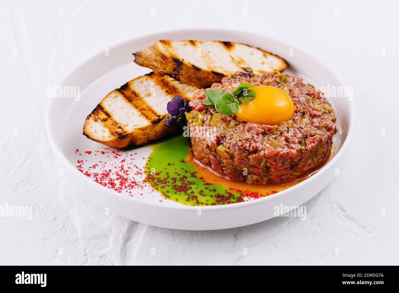 Bistecca gourmet alla tartare con tuorlo d'uovo e pane tostato Foto Stock