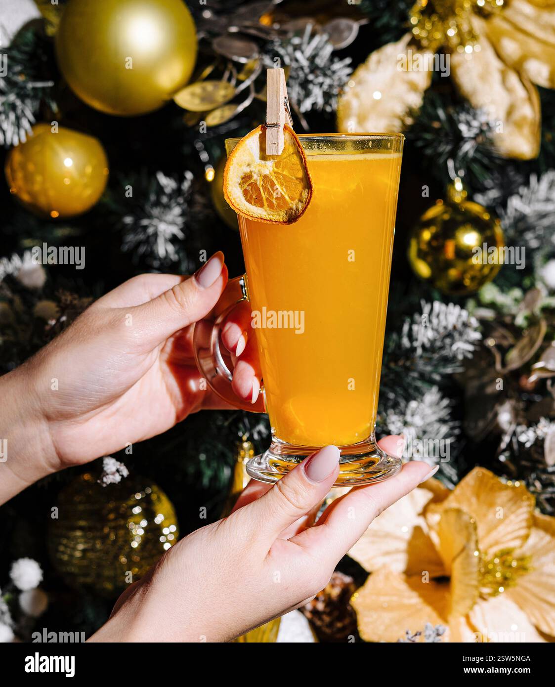 Drink natalizio a portata di mano accanto all'albero di natale Foto Stock