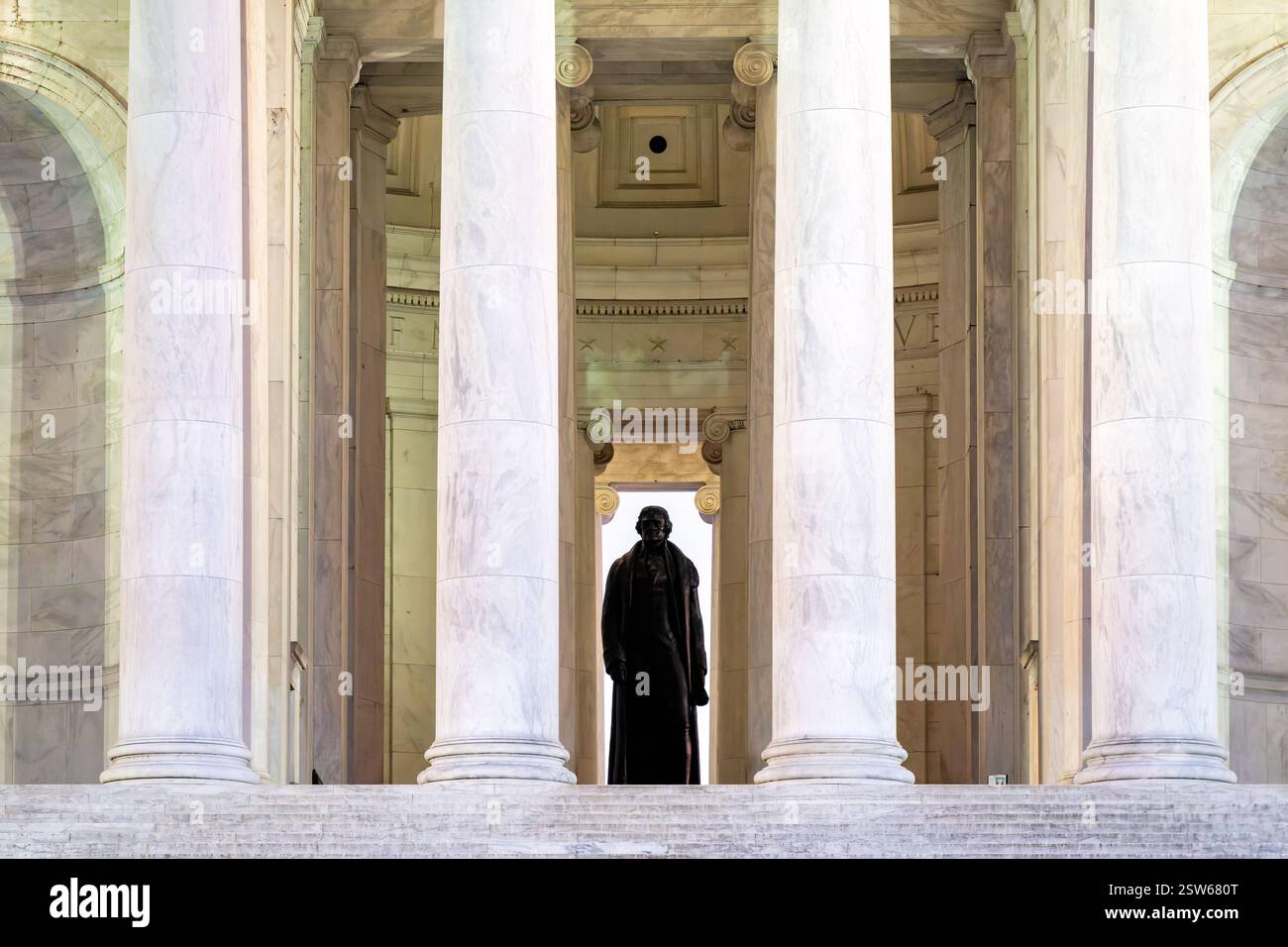 WASHINGTON DC - la statua di bronzo di Thomas Jefferson è vista attraverso le colonne ioniche all'ingresso del Thomas Jefferson Memorial. La scultura di 19 piedi creata dall'artista Rudulph Evans raffigura il terzo presidente degli Stati Uniti in piedi con la dichiarazione di indipendenza in mano. Il memoriale fu dedicato nel 1943 in occasione del 200° anniversario della nascita di Jefferson. Foto Stock