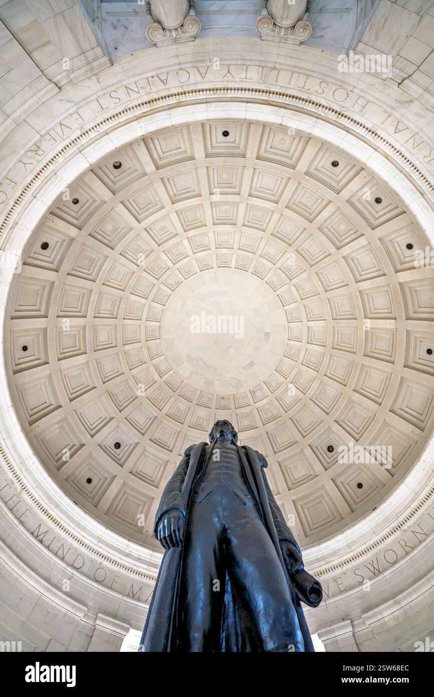 WASHINGTON DC - una vista verso l'alto dall'interno del Thomas Jefferson Memorial cattura la statua di bronzo di 19 piedi di Jefferson e il soffitto a volta a cassettoni sopra. La statua, creata dallo scultore Rudulph Evans, si erge sotto il tetto a cupola ispirato all'architettura romana classica. La camera interna circolare presenta pannelli incisi con citazioni degli scritti di Jefferson che circondano la somiglianza del terzo presidente. Foto Stock