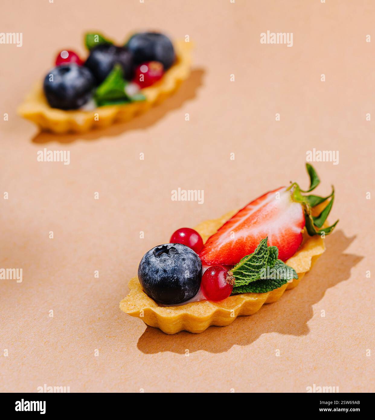 Mini crostate di frutta colorate sullo sfondo caldo Foto Stock