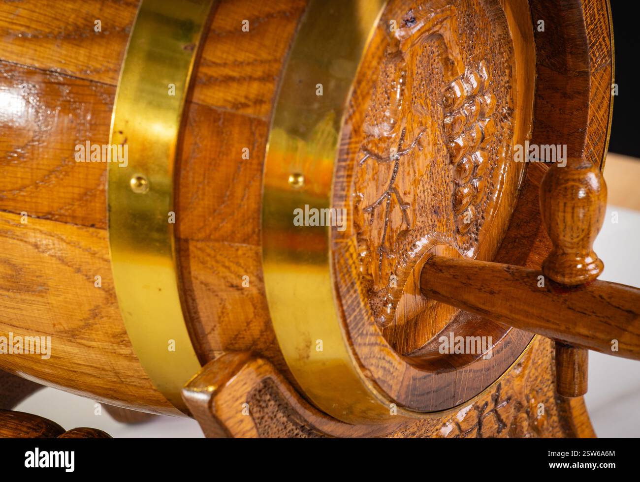 Un barile decorativo in legno con intagli di vite, artigianato vintage e una superficie riflettente, ideale per concept design o temi rustici. Foto Stock