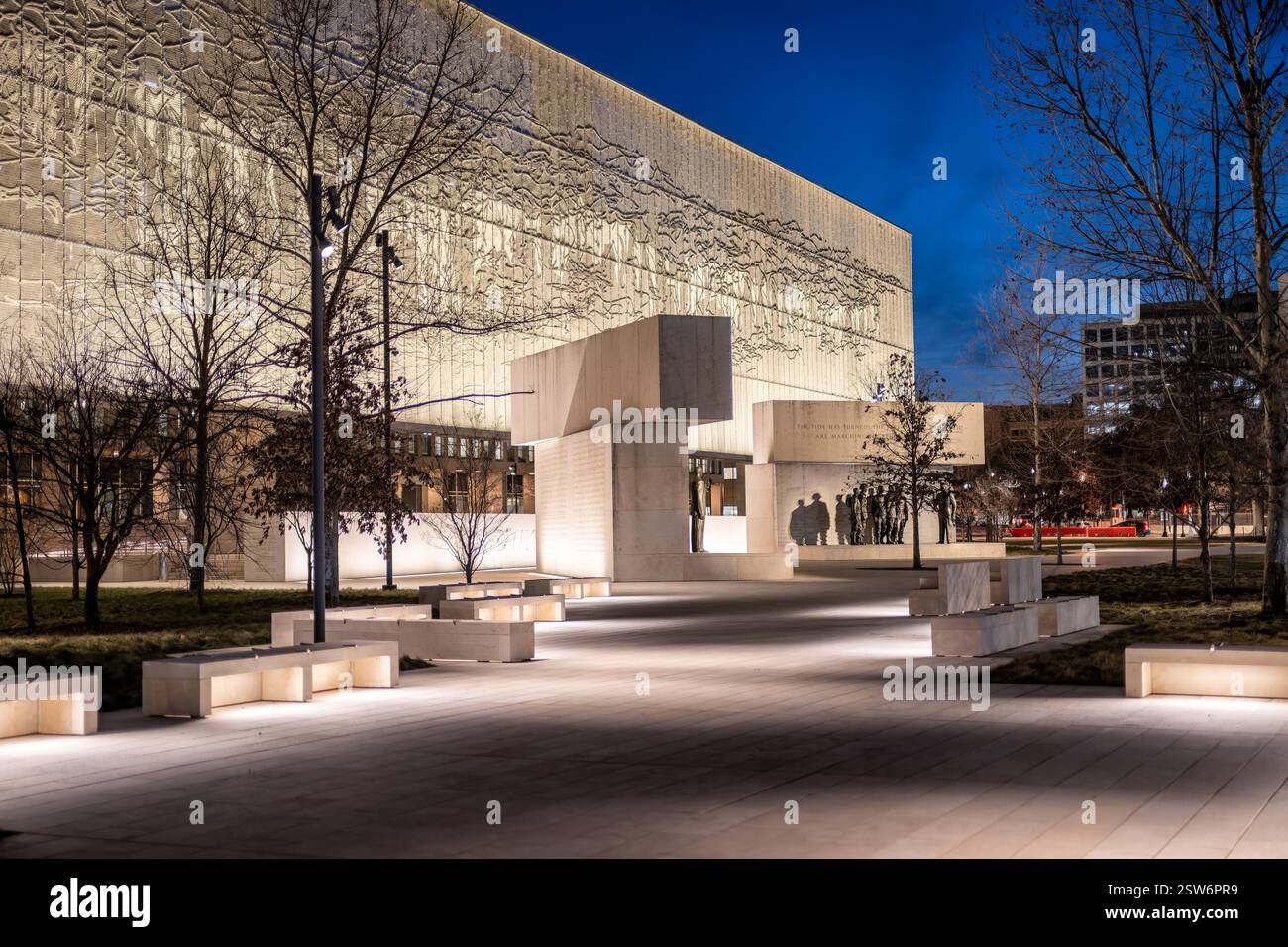 WASHINGTON DC - il Dwight D. Eisenhower Memorial si illumina di notte, mettendo in risalto i suoi arazzi in acciaio inossidabile e gli elementi scultorei. Progettato dall'architetto Frank Gehry e dedicato nel settembre 2020, il memoriale onora il 34° Presidente degli Stati Uniti e Comandante Supremo delle forze alleate nella seconda guerra mondiale. Il sito di quattro acri presenta statue in bronzo raffiguranti Eisenhower nei momenti chiave della sua vita, circondato da blocchi di pietra calcarea e dai caratteristici arazzi in metallo intrecciato raffiguranti la costa della Normandia. Situato in un ambiente simile a un parco vicino al National Mall e all'acros Foto Stock