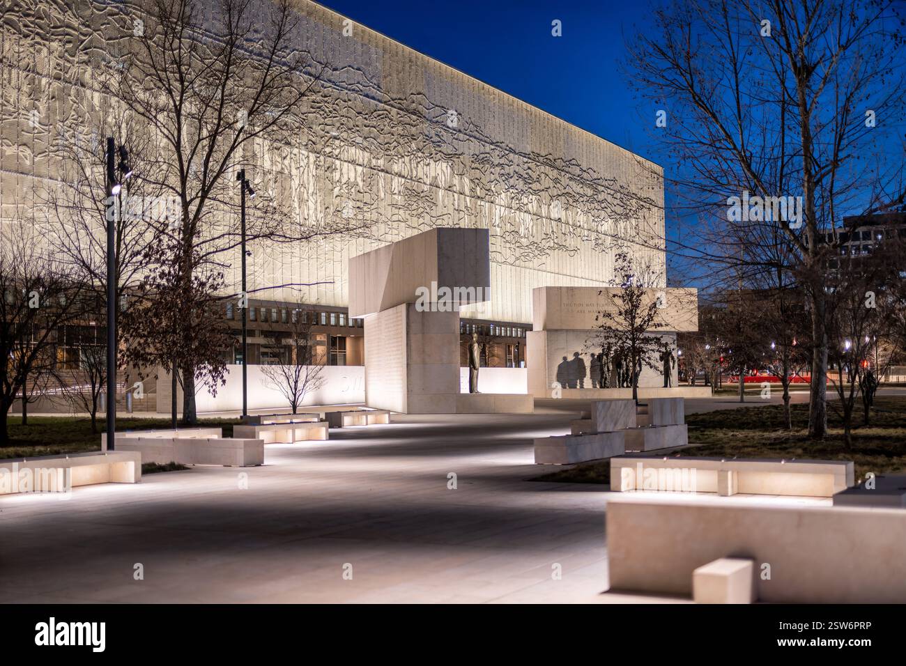 WASHINGTON DC - il Dwight D. Eisenhower Memorial si illumina di notte, mettendo in risalto i suoi arazzi in acciaio inossidabile e gli elementi scultorei. Progettato dall'architetto Frank Gehry e dedicato nel settembre 2020, il memoriale onora il 34° Presidente degli Stati Uniti e Comandante Supremo delle forze alleate nella seconda guerra mondiale. Il sito di quattro acri presenta statue in bronzo raffiguranti Eisenhower nei momenti chiave della sua vita, circondato da blocchi di pietra calcarea e dai caratteristici arazzi in metallo intrecciato raffiguranti la costa della Normandia. Situato in un ambiente simile a un parco vicino al National Mall e all'acros Foto Stock