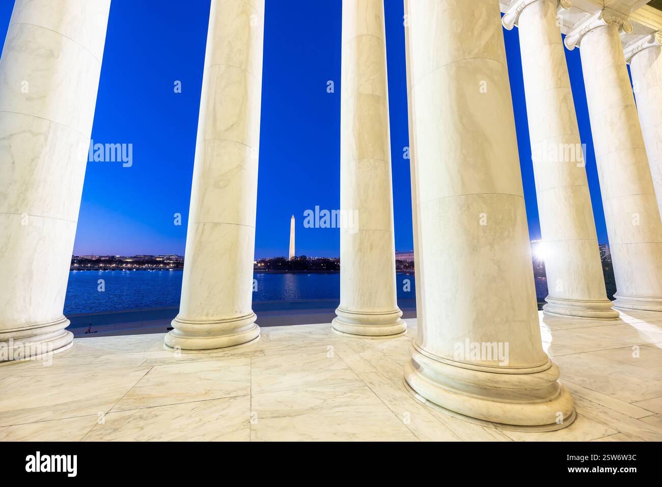 WASHINGTON DC - il Washington Monument è incorniciato dalle colonne di marmo del Thomas Jefferson Memorial al crepuscolo. Il bacino delle maree si estende tra i due monumenti iconici del National Mall. Il Jefferson Memorial, progettato dall'architetto John Russell Pope, fu dedicato nel 1943 in onore del terzo presidente degli Stati Uniti. Foto Stock