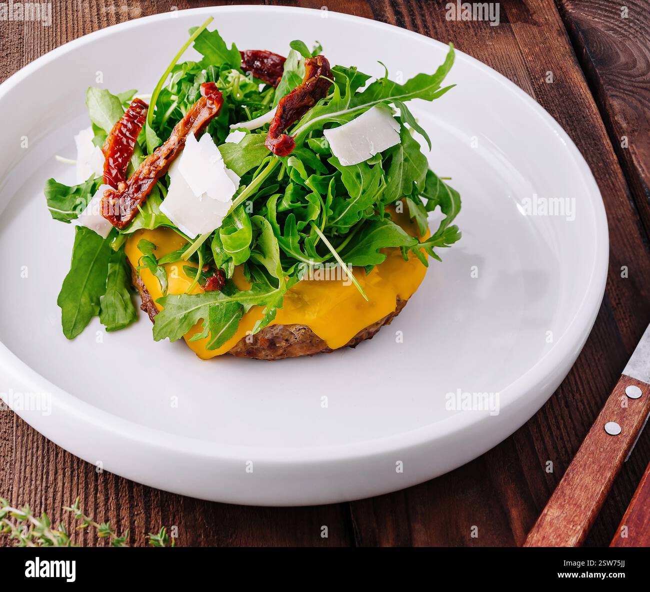 Cheeseburger gourmet con rucola e pomodori secchi Foto Stock