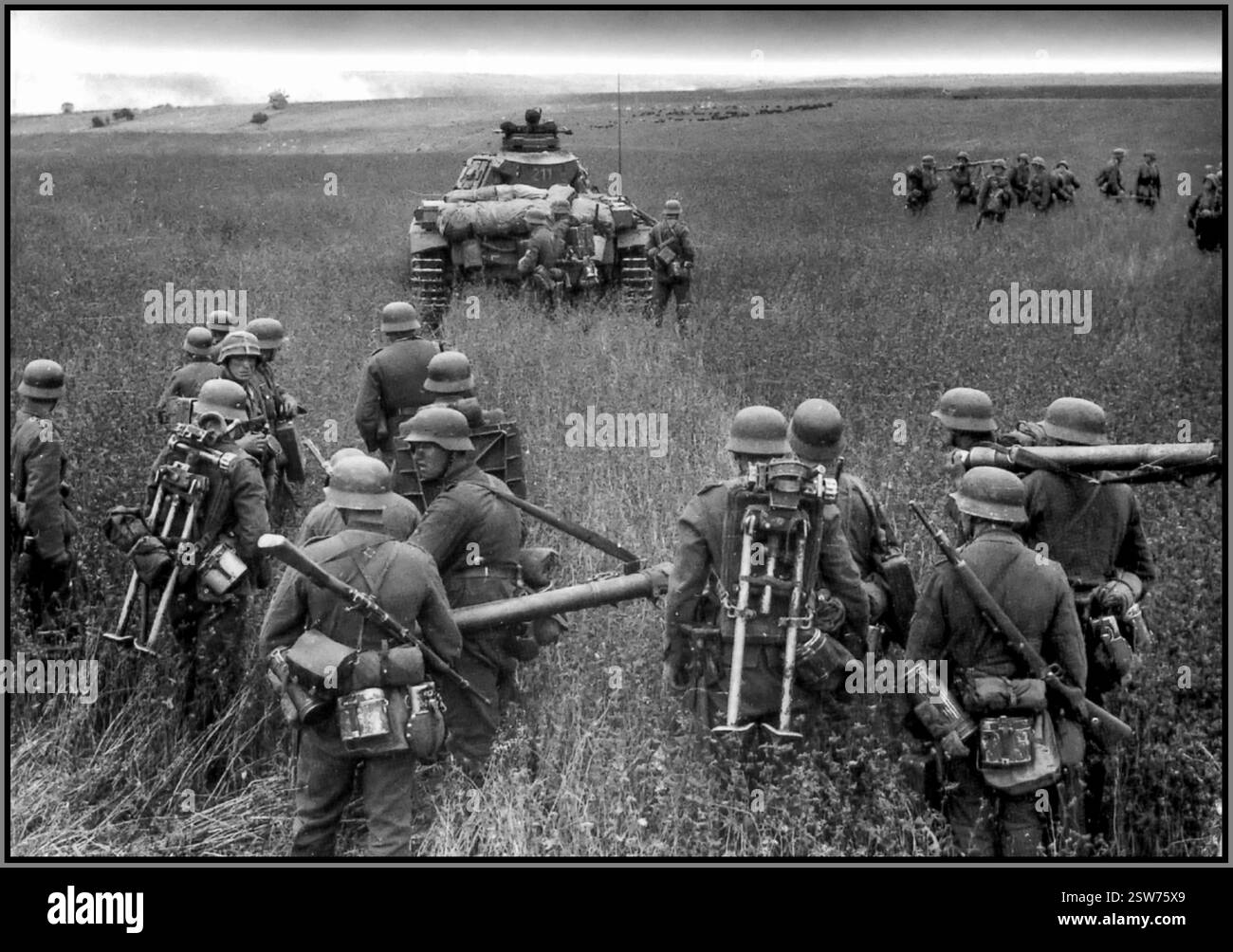 I soldati tedeschi BARBAROSSA e un carro armato Panzer III durante l'operazione Barbarossa nel 1941. Questa operazione fu l'invasione tedesca dell'Unione Sovietica durante la seconda guerra mondiale. I soldati sono fanteria della Wehrmacht, fornendo supporto e protezione al carro armato in avanzata. Trasportano attrezzature, tra cui armi, munizioni e rifornimenti. Foto Stock