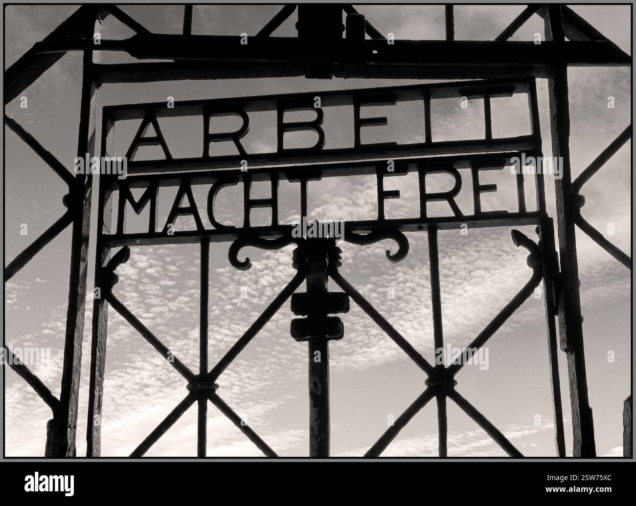 Porta d'ingresso DI DACHAU al campo di concentramento nazista di DACHAU, con la famigerata frase "Arbeit macht frei" ("il lavoro ti libera"). Dachau fu il primo campo di concentramento nazista, fondato nel 1933 vicino a Monaco di Baviera, in Germania. Servì come modello per altri campi di concentramento e un centro di formazione per il personale delle SS. Lo slogan "Arbeit macht frei" è stato utilizzato all'ingresso di diversi campi di concentramento nazisti. Era destinato a ingannare i prigionieri e mascherare il vero scopo del campo, il lavoro forzato e lo sterminio. Dachau fu liberata dalle forze americane il 29 aprile 1945. Foto Stock