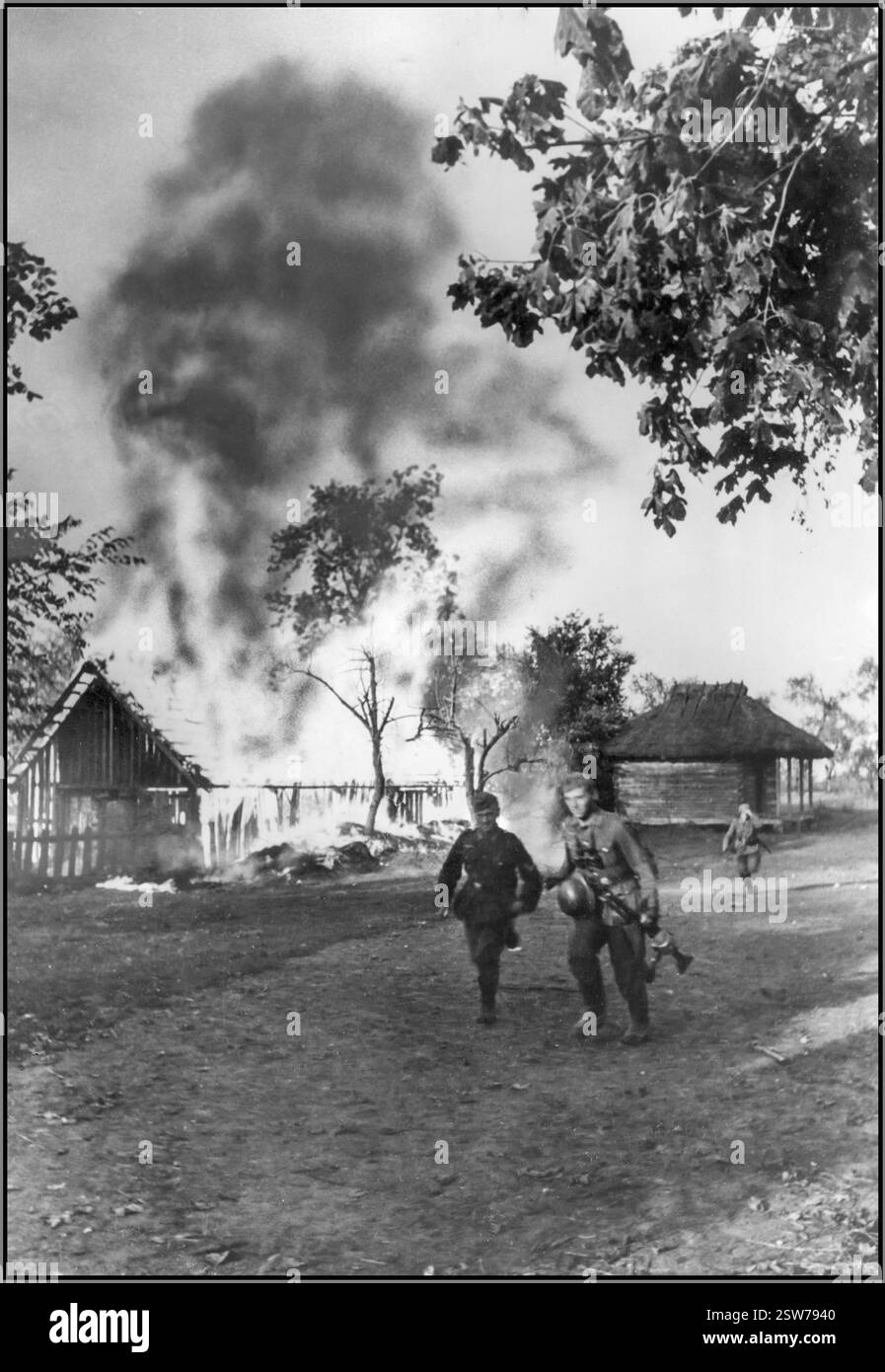 Barbarossa fanteria tedesca nazista in un villaggio in fiamme sul fronte orientale. CrimesOperazione Barbarossa con l'avanzare dei soldati nazisti della Wehrmacht che trasportavano una mitragliatrice e indossavano stivali, con nuvole di fumo e fiamme sullo sfondo di un villaggio sovietico bruciato fu l'invasione dell'Unione Sovietica da parte della Germania nazista e di molti dei suoi alleati dell'asse, a partire da domenica 22 giugno 1941, durante la seconda guerra mondiale. Fu la più grande offensiva terrestre della storia umana, con circa 10 milioni di combattenti che parteciparono Foto Stock