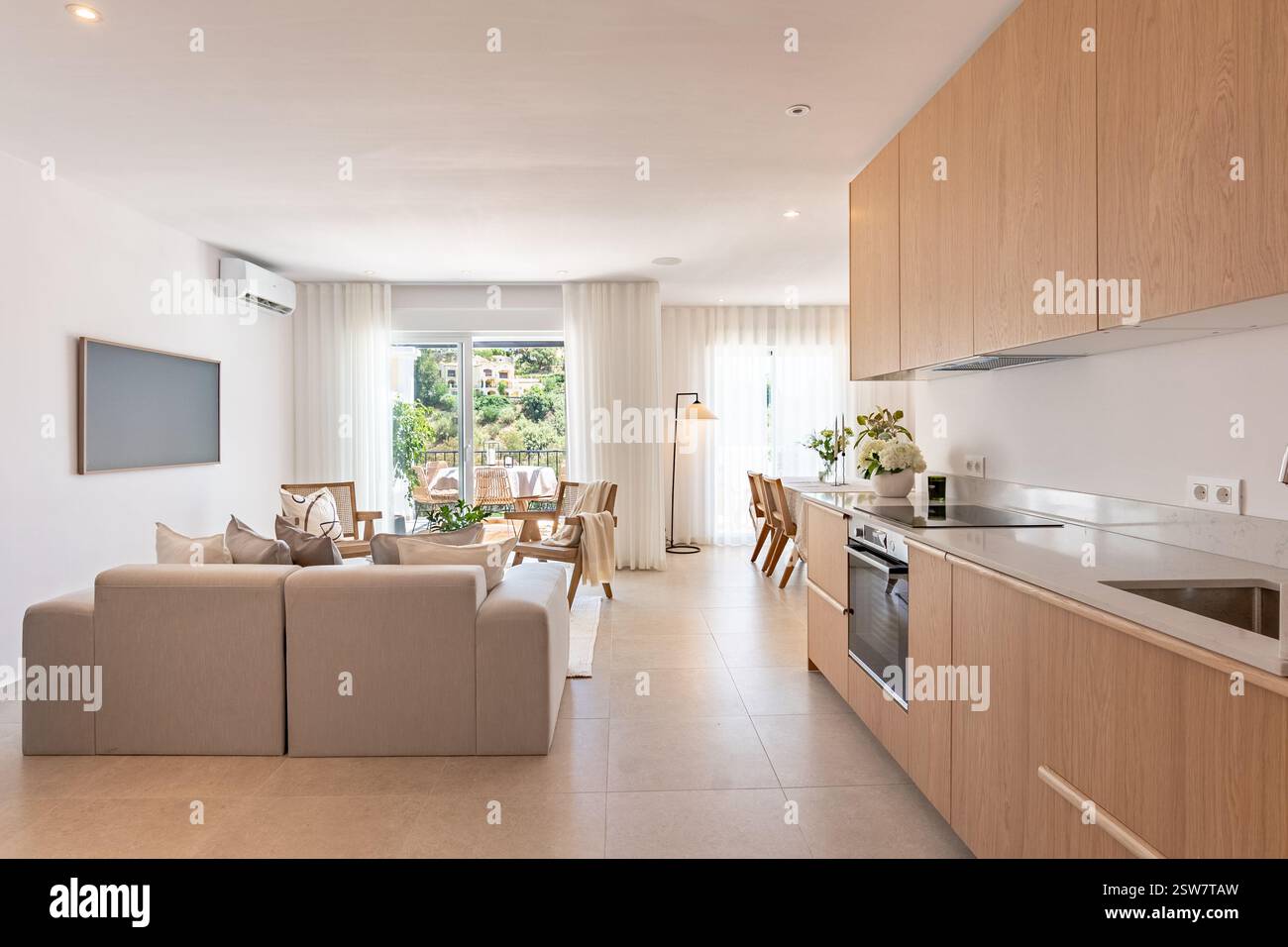 un'immagine di una cucina a vista e di uno spazio salotto in una lussuosa casa vacanze mediterranea Foto Stock