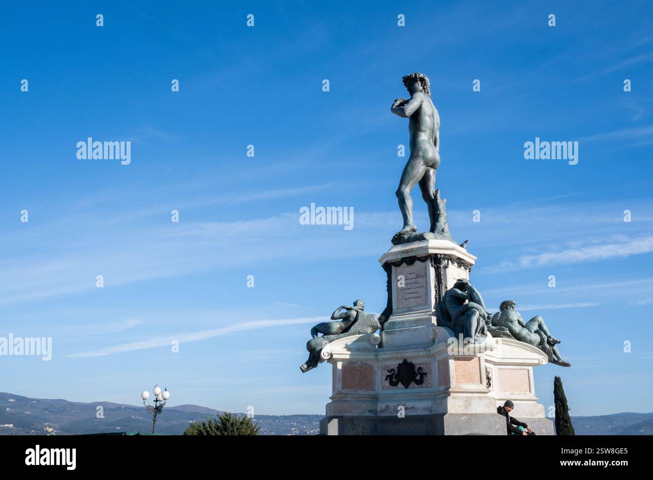 Vista posteriore della scultura di David di Miguel Angel. È a Firenze, in Toscana, in Italia. Il sole dell'alba illumina la sua schiena e ci sono alcune nuvole Foto Stock
