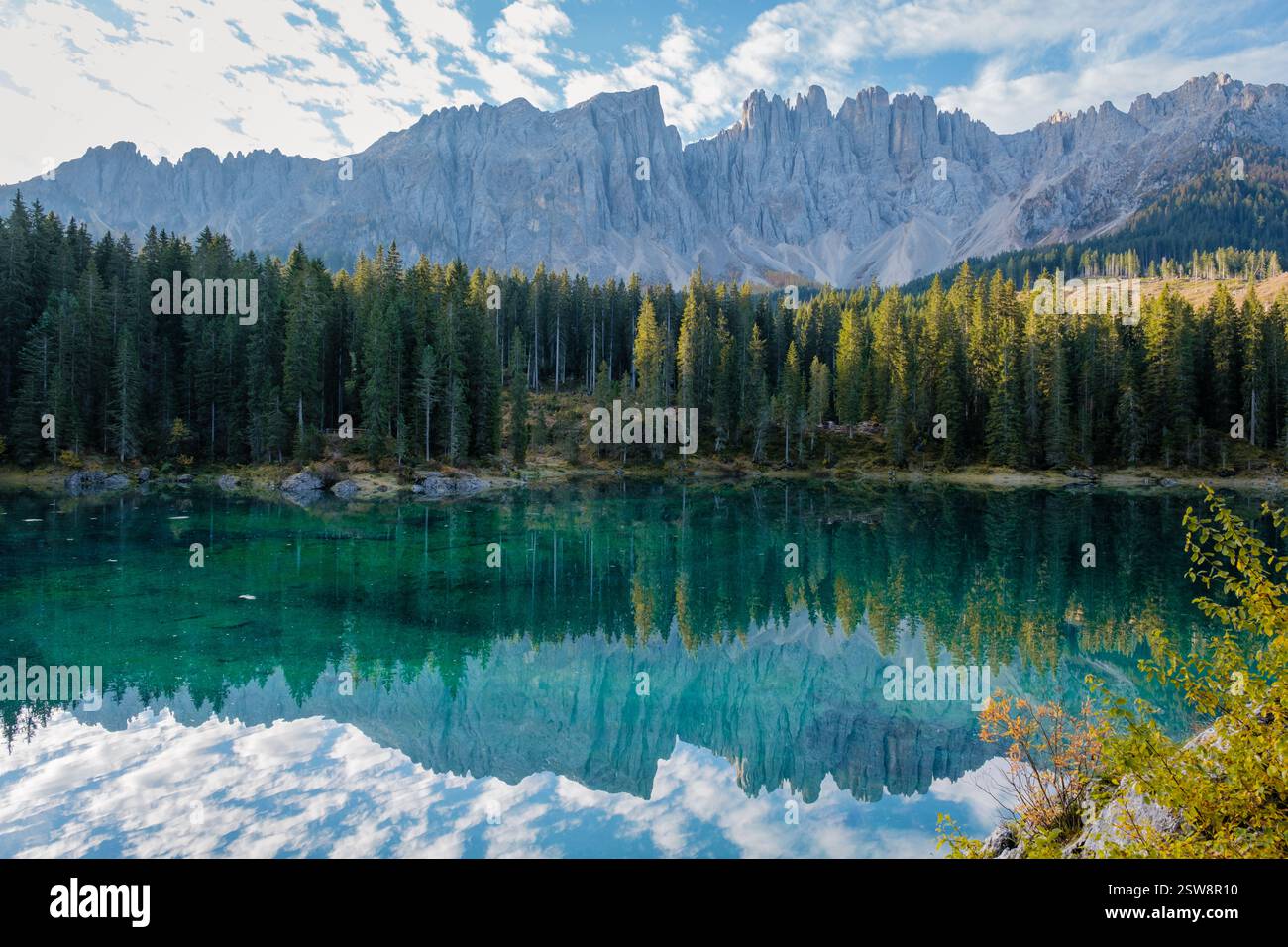 Riflessi mozzafiato delle Dolomiti in un tranquillo lago alpino in autunno Foto Stock