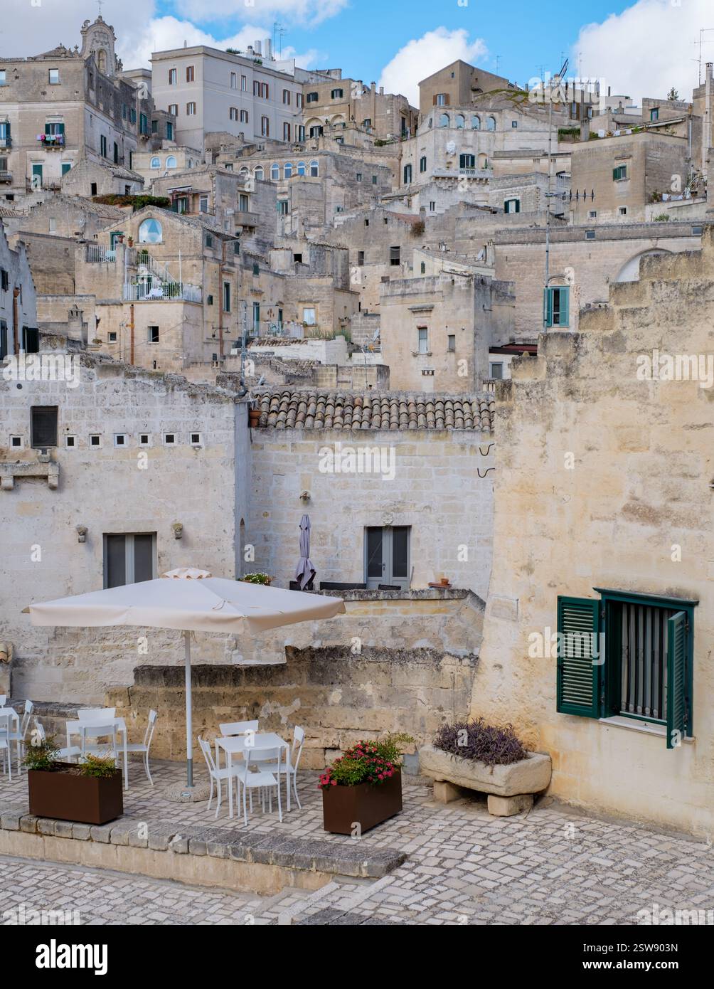 Incantevole cortile a Matera, Puglia, Italia, che mostra antichi edifici in pietra e una cultura vivace Foto Stock