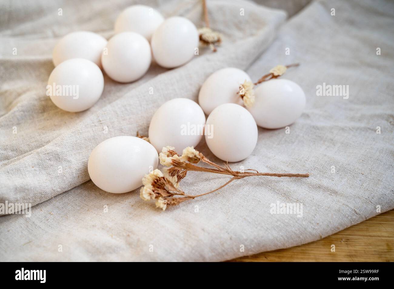 uova di pollo bianche giacciono sul tavolo su una tovaglia di lino naturale Foto Stock