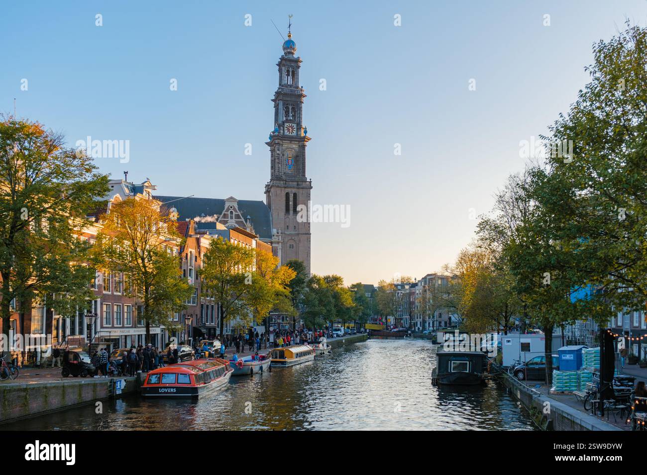 Colori autunnali e l'iconica torre vicino ai tranquilli canali di Amsterdam durante l'ora d'oro Foto Stock