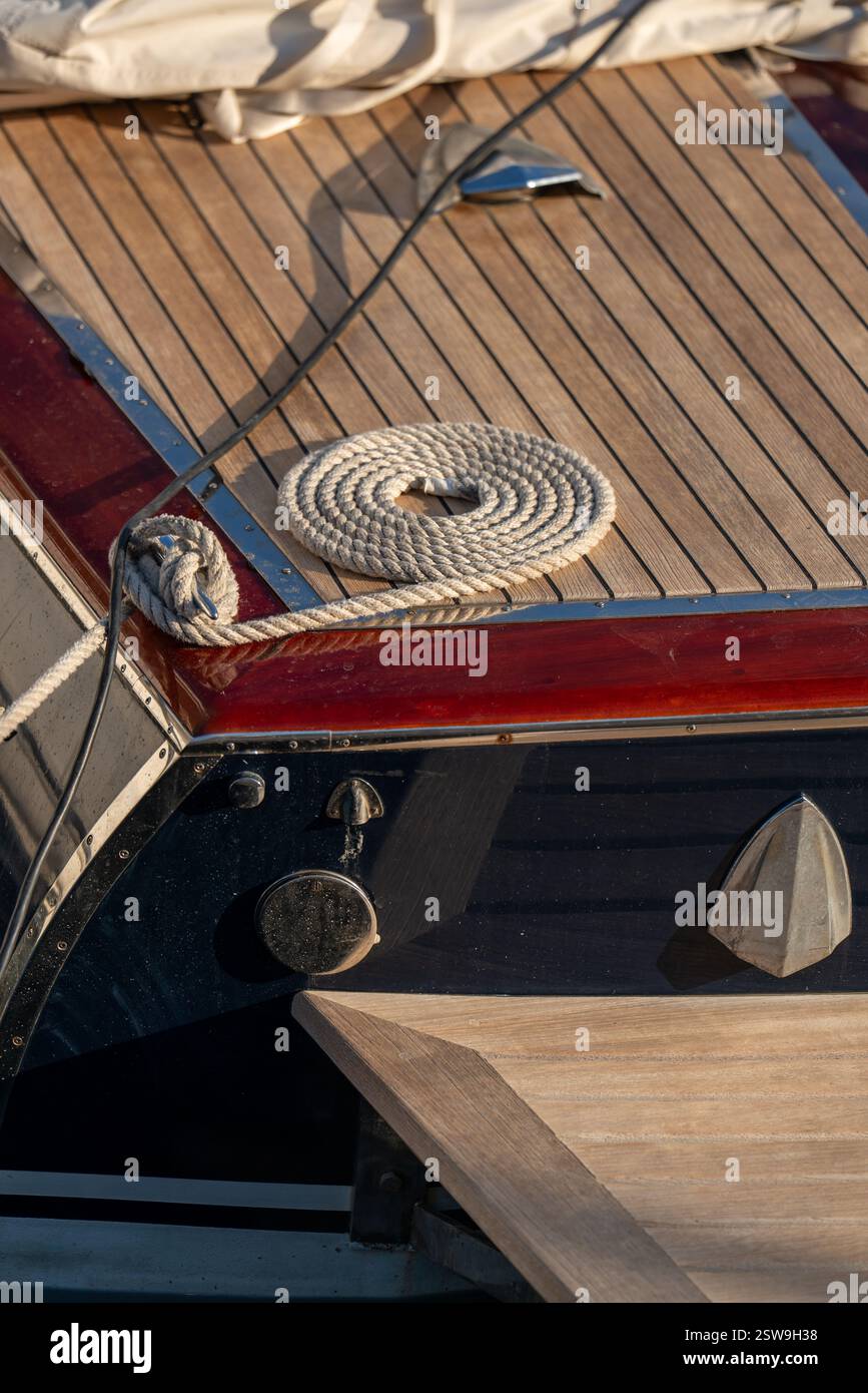 Fune di ormeggio a spirale che riposa sul ponte dello yacht, catturando l'essenza della vita nautica. Dettaglio ravvicinato delle attrezzature marittime sullo sfondo di open S Foto Stock