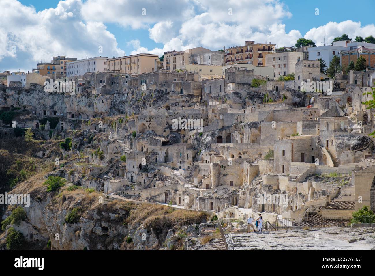 Esplorando le antiche abitazioni rupestri di Matera in Puglia, Italia sotto un bellissimo cielo blu Foto Stock