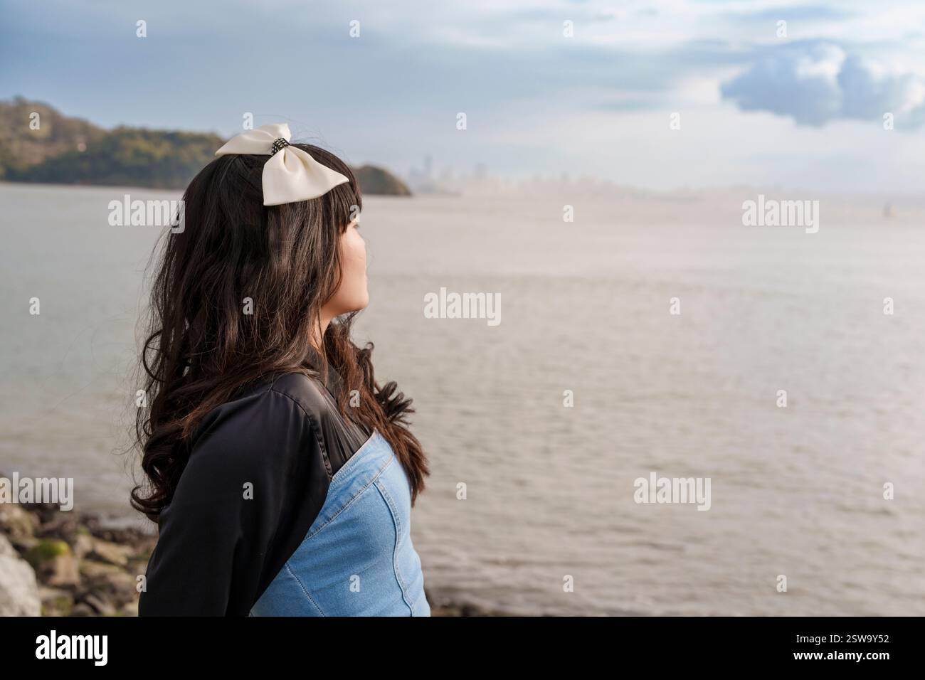 Giovane donna che indossa Bow San Francisco Bay Cloudy Day Foto Stock