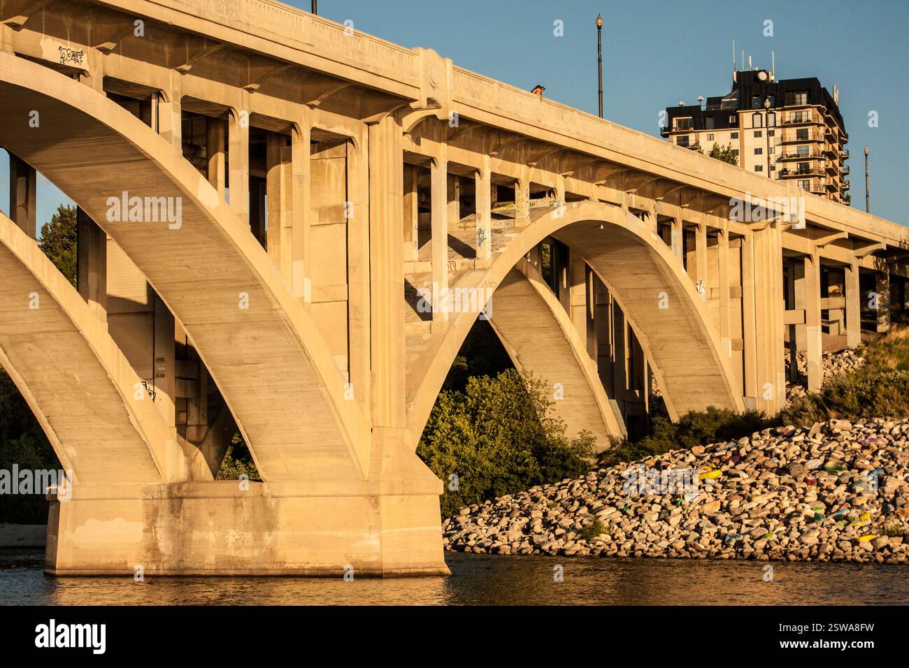 Ponte con un grande arco sopra un fiume. Il ponte è fatto di cemento ed è molto lungo Foto Stock