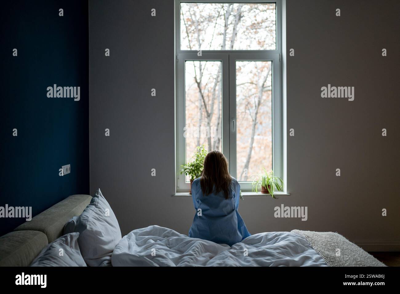 Donna sola sedersi a letto a casa meditando problemi di soluzione, soffrono di rottura, divorzio, sentirsi malessere Foto Stock