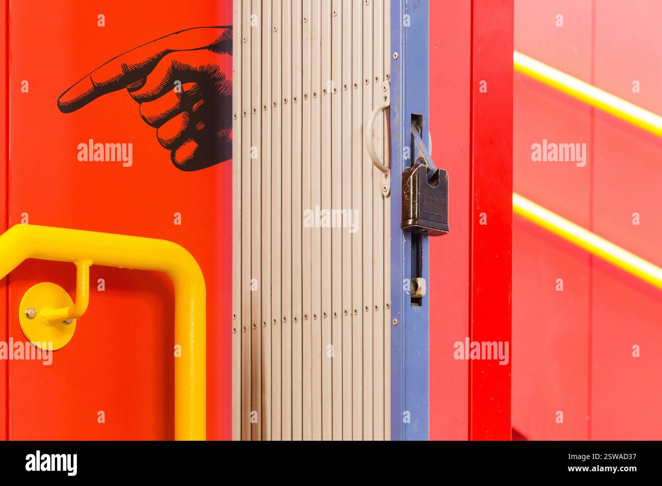 Porta a fisarmonica chiusa a chiave, probabilmente su un autobus o un treno dipinto di rosso, presso un hub di transito. Misure di sicurezza. Foto Stock
