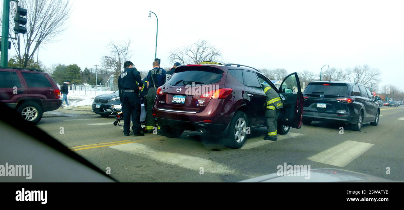 I vigili del fuoco e i paramedici aiutano a recuperare le vittime sul luogo di un incidente automobilistico. Minneapolis, Minnesota, Minnesota, Stati Uniti Foto Stock