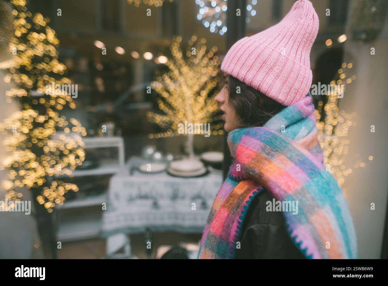 Un'accogliente scena invernale piena di luci decorative e abbigliamento caldo che cattura le vivaci vibrazioni stagionali Foto Stock