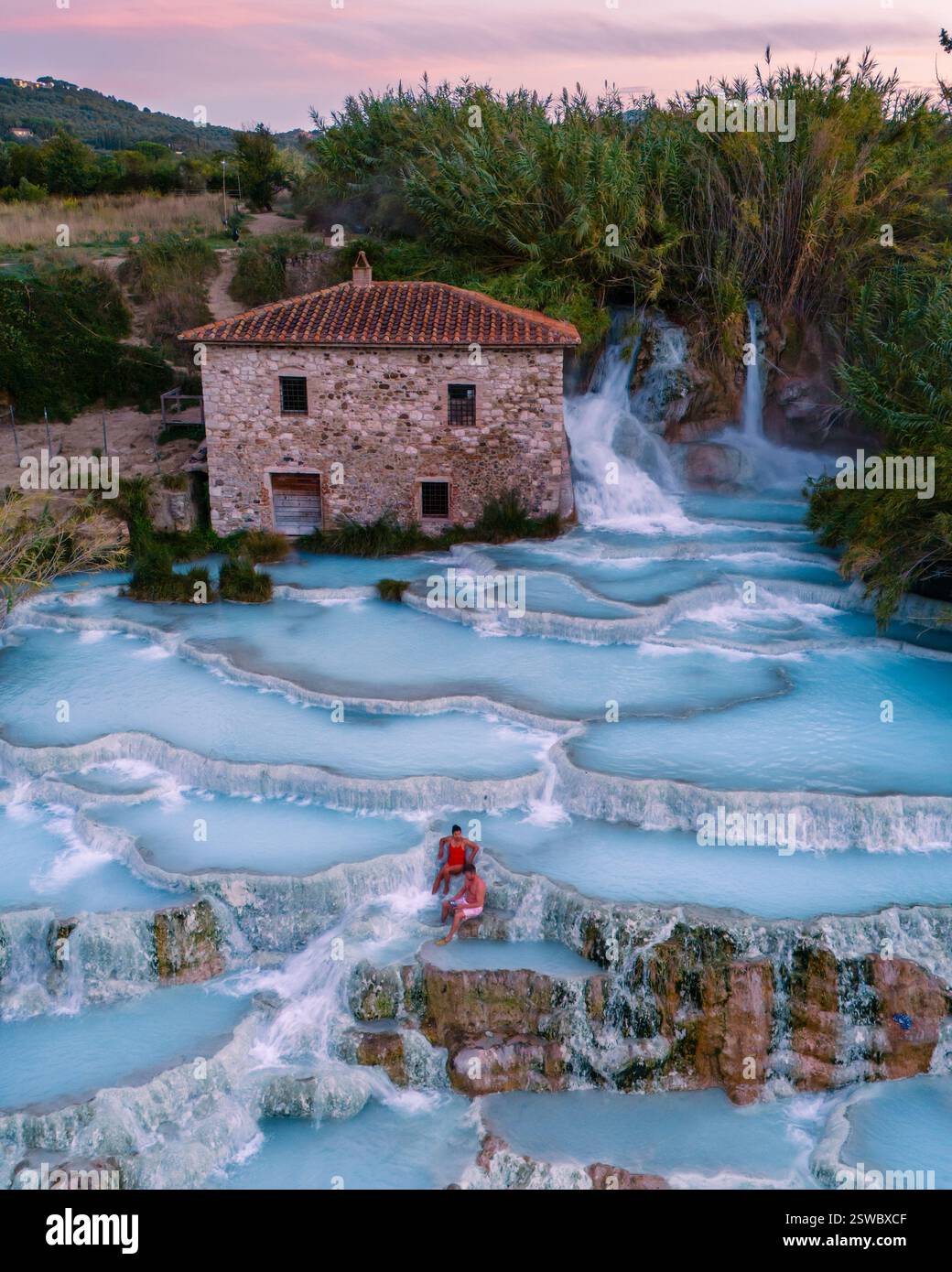 Rilassatevi nelle terme naturali di Saturnia sotto il caldo bagliore del tramonto toscano Foto Stock