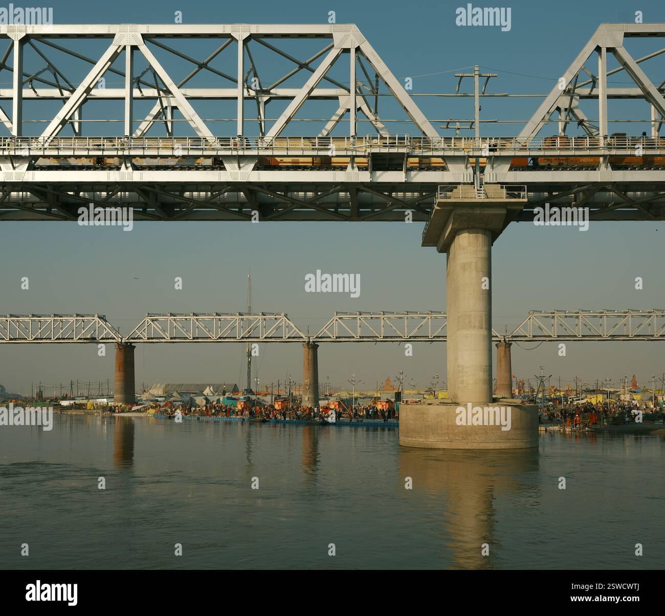 I pellegrini si riuniscono in una folla vibrante a Triveni Sangam presso il Maha Kumbh Mela, celebrando la loro fede con un tuffo sacro sul lungofiume di Prayagraj. Foto Stock